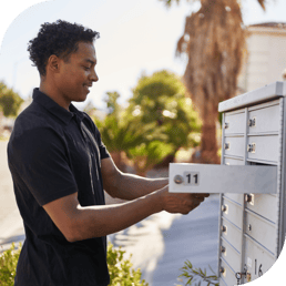 a man receives physical mail from a community mailbox