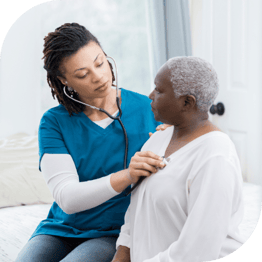 a doctor or nurse listens to the heart of a woman with gray hair with a stethoscope 
