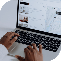 A person browses Airbnb short-term rentals on a laptop