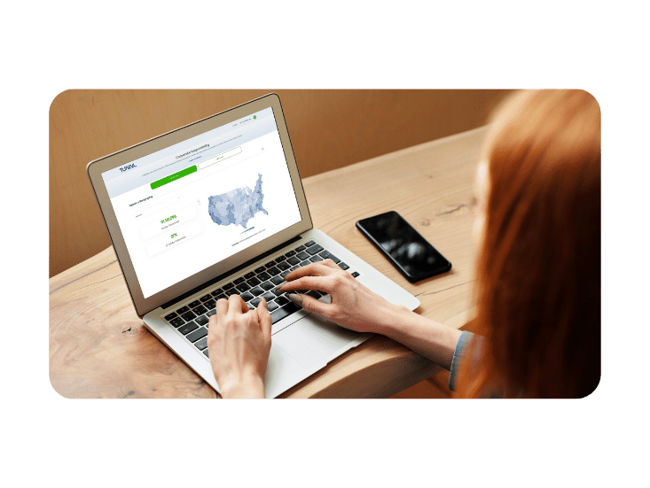Woman with read hair using laptop with Tunnl platform