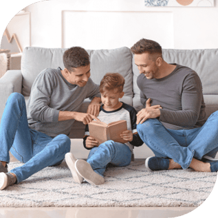 a gay couple reads a book with their son