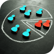 six blue wooden blocks sit in the larger section of a pie chart drawn in white chalk. two red wooden blocks sit in the smaller section of the chart.