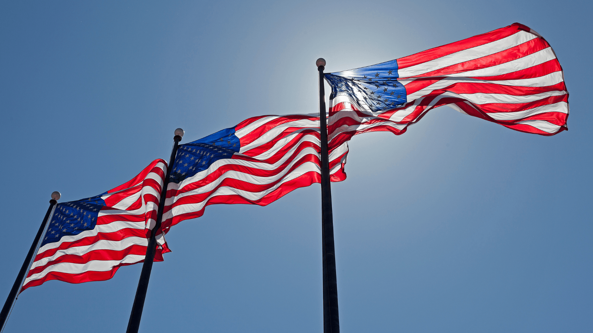 3 American flags flying in the wind